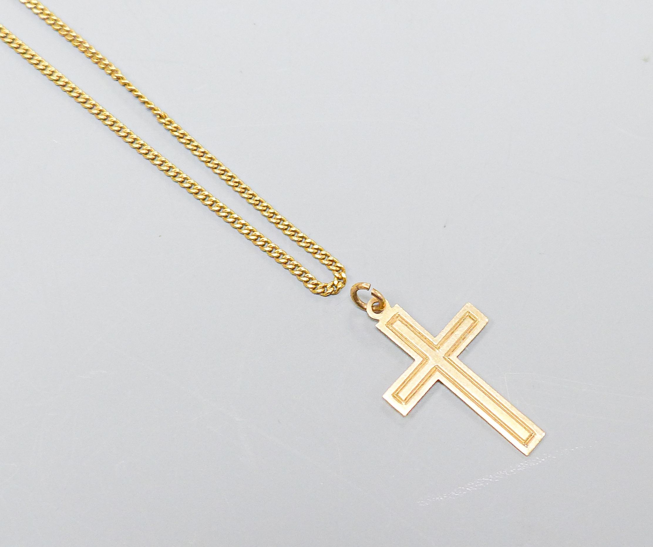 An 18ct yellow gold fine curb-link necklet, 51cm, 5 grams and a 9ct crucifix, 0.8 grams.